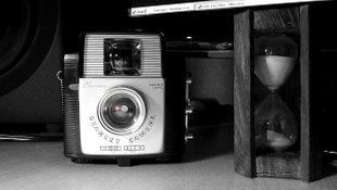 Photo of an old camera, Kodak Brownie and a hourglass.